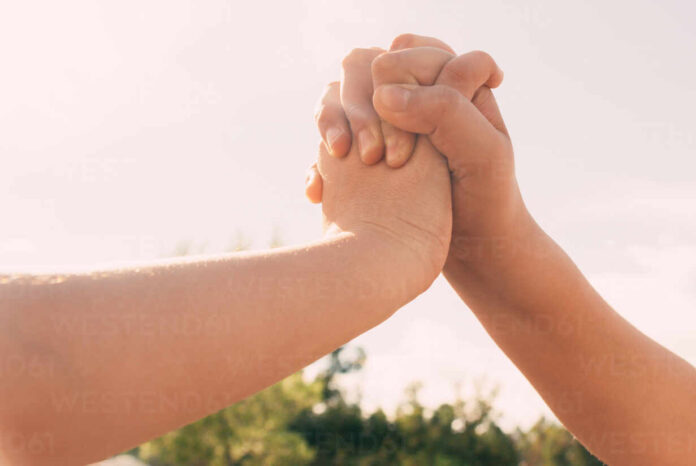 Union of intertwined hands two sisters in the background of the blue sky, Family